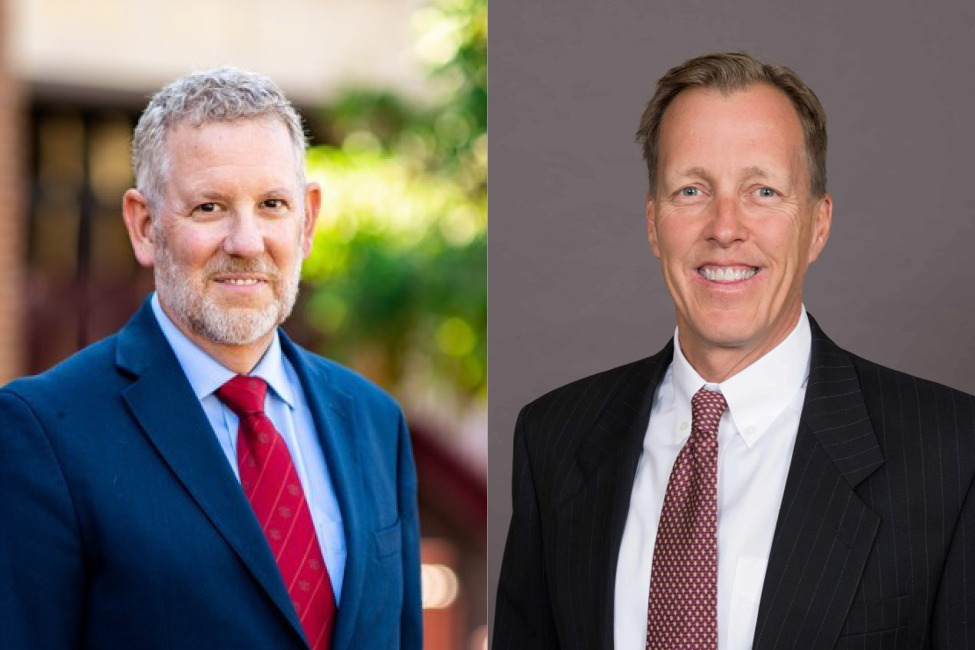 Two men in suits, one with gray hair, one with sandy hair, both smiling