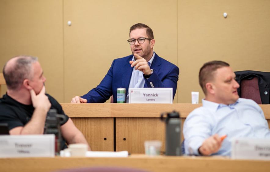 2 men having a discussion in class.