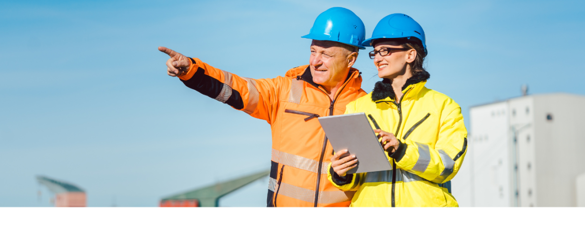 While standing in a shipping yard, a man in a hardhat points into the distance while a woman in a hardhat checks figures on a clipboard.  "Move Forward" is written on the image.